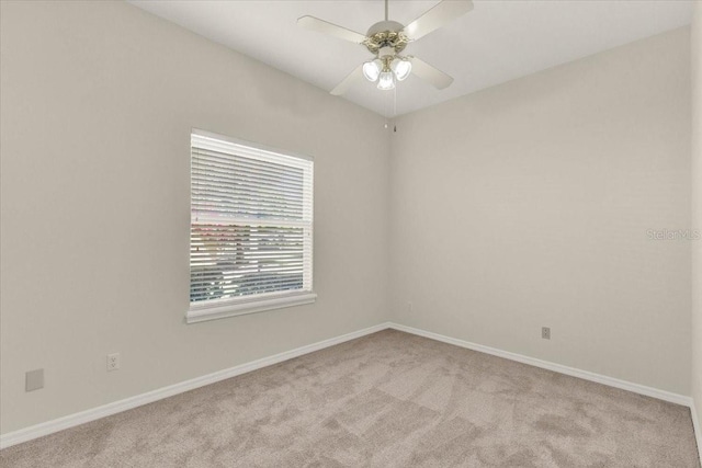 spare room featuring carpet flooring, baseboards, and a ceiling fan