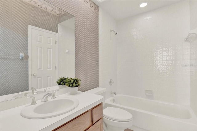 full bath featuring wallpapered walls, toilet, vanity, and shower / bathtub combination