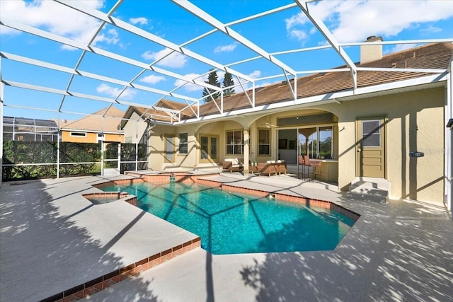 view of swimming pool with glass enclosure, a patio, and a pool with connected hot tub