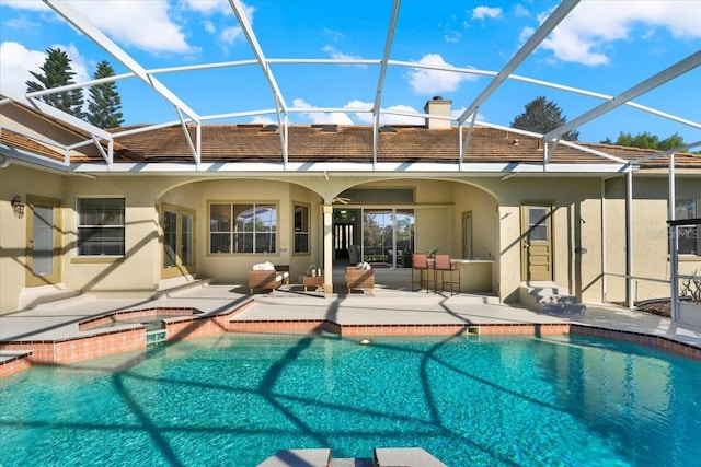 view of swimming pool with a lanai, a pool with connected hot tub, and a patio