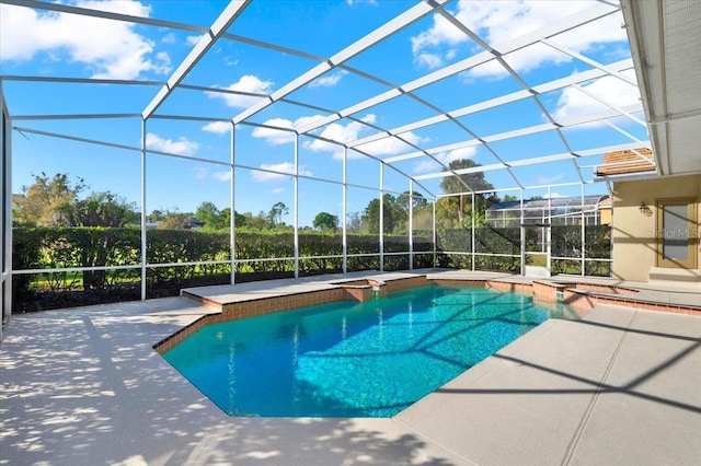 outdoor pool featuring glass enclosure and a patio