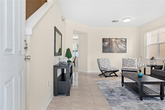 living area featuring light tile patterned floors, baseboards, and visible vents