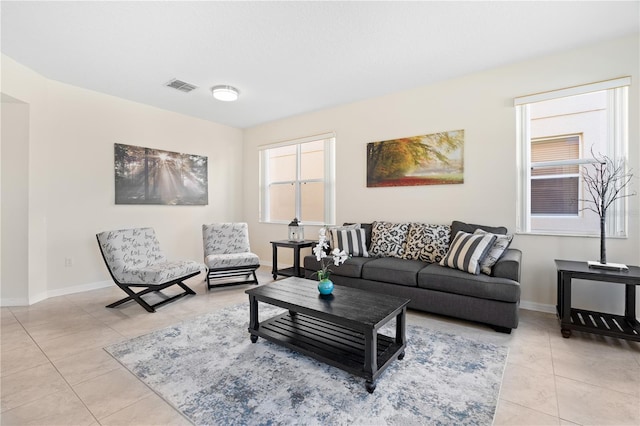 living area with light tile patterned floors, visible vents, and baseboards