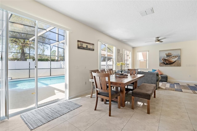 dining area featuring light tile patterned floors, visible vents, a textured ceiling, and baseboards