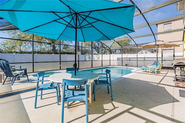 view of swimming pool with a fenced in pool, fence, a lanai, and a patio area