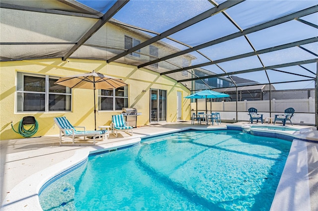 view of swimming pool with a pool with connected hot tub, fence, glass enclosure, a patio area, and a grill