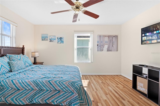 bedroom featuring light wood-style floors, baseboards, and ceiling fan