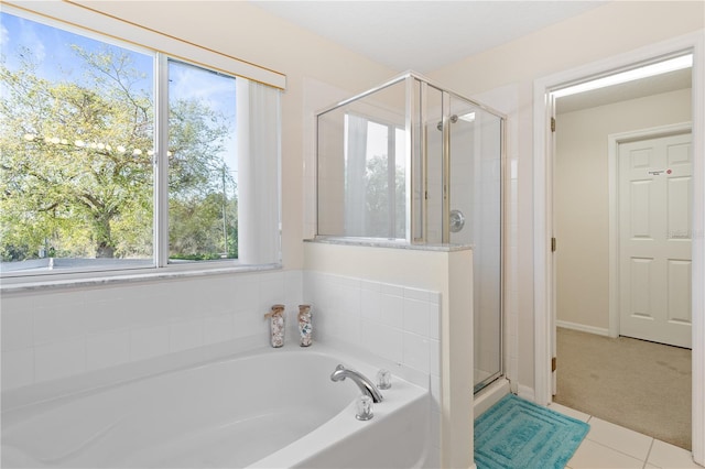 full bathroom featuring tile patterned flooring, a shower stall, and a bath