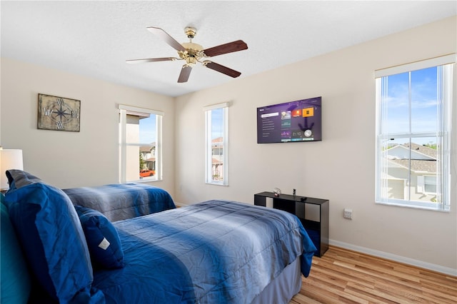 bedroom with baseboards, light wood-style floors, and ceiling fan