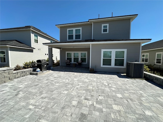 rear view of property featuring a patio area and central AC