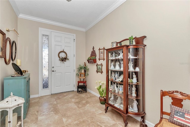 foyer featuring baseboards and ornamental molding