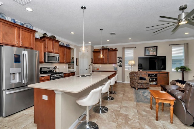 kitchen featuring a sink, brown cabinets, open floor plan, and stainless steel appliances