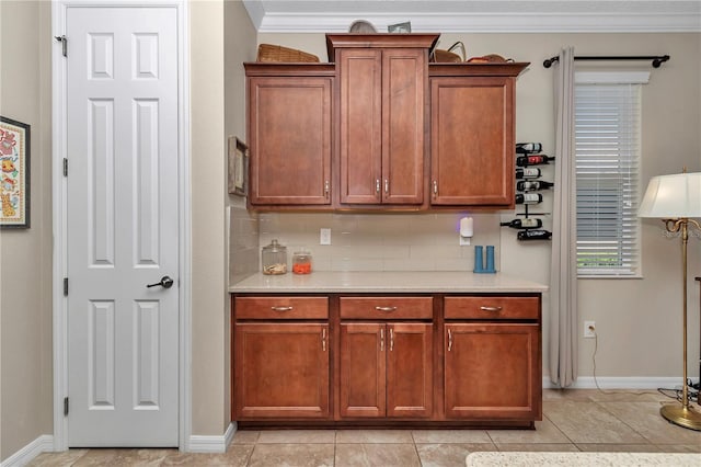 kitchen with decorative backsplash, ornamental molding, light tile patterned flooring, and light countertops