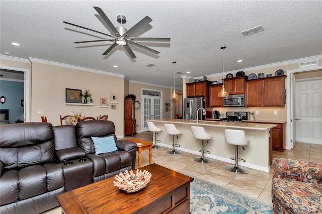 living area with light tile patterned floors, visible vents, and a textured ceiling