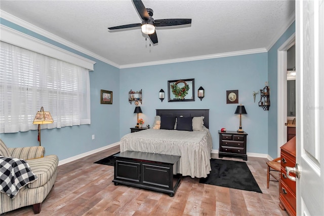 bedroom featuring crown molding, light wood-style flooring, and baseboards