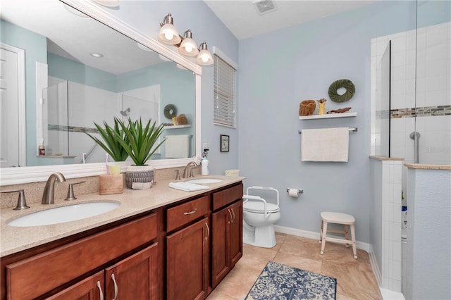 bathroom featuring visible vents, tiled shower, and a sink