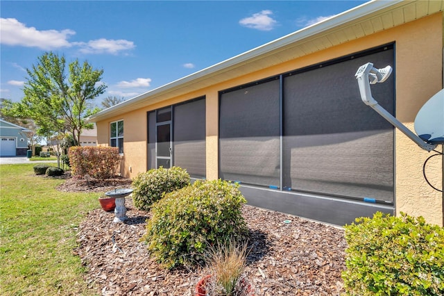 exterior space with stucco siding and a lawn