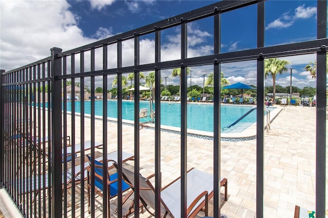 community pool featuring a patio area and fence