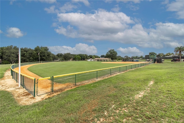 view of property's community featuring a rural view, a gate, fence, and a yard