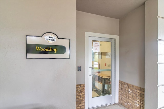 doorway to property featuring stone siding and stucco siding