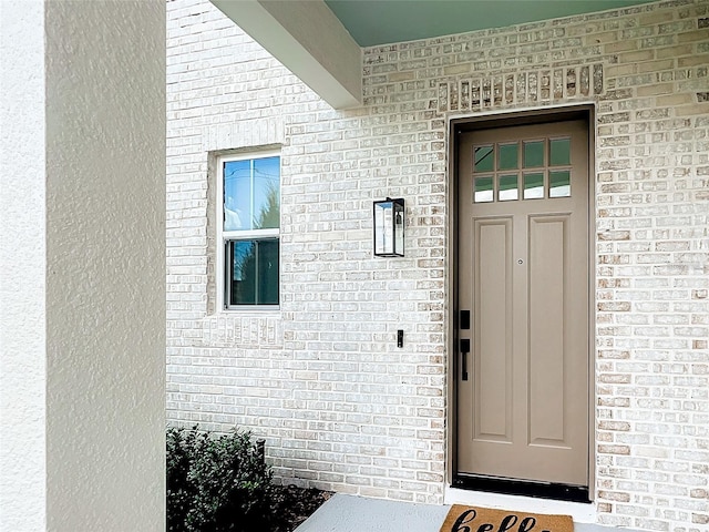 doorway to property featuring brick siding