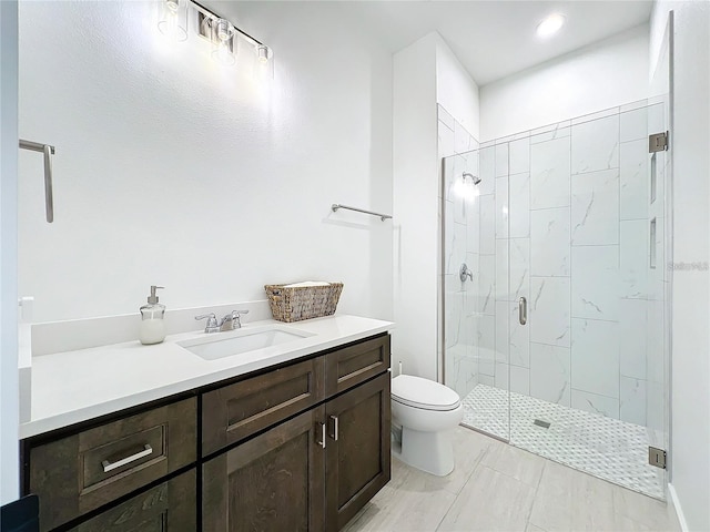 bathroom with vanity, toilet, and a stall shower