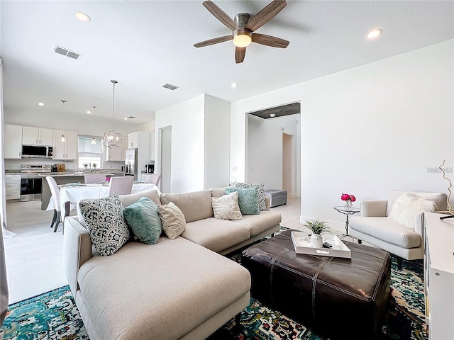 living room with a ceiling fan, recessed lighting, and visible vents