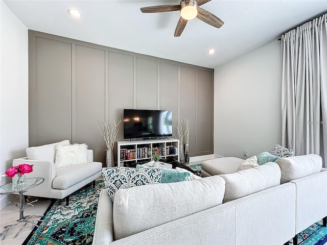 living area featuring a decorative wall, recessed lighting, and a ceiling fan