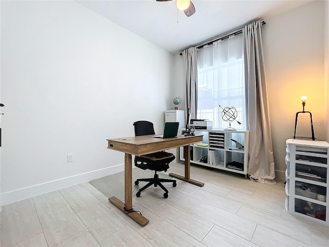 home office with ceiling fan and baseboards