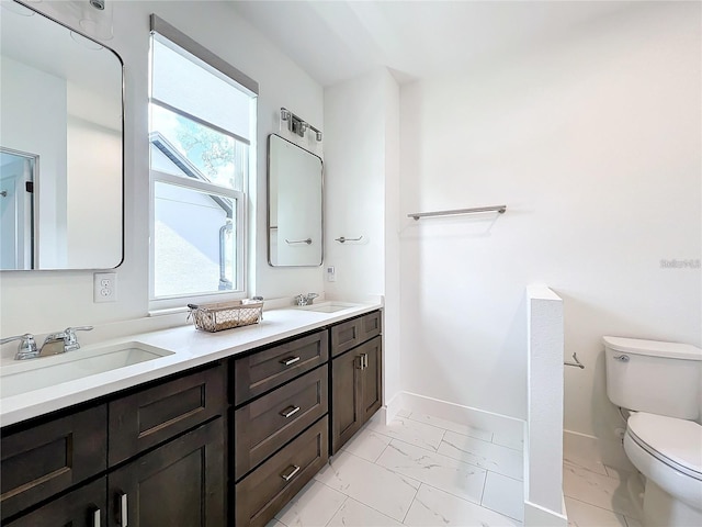 full bath with marble finish floor, toilet, baseboards, and a sink