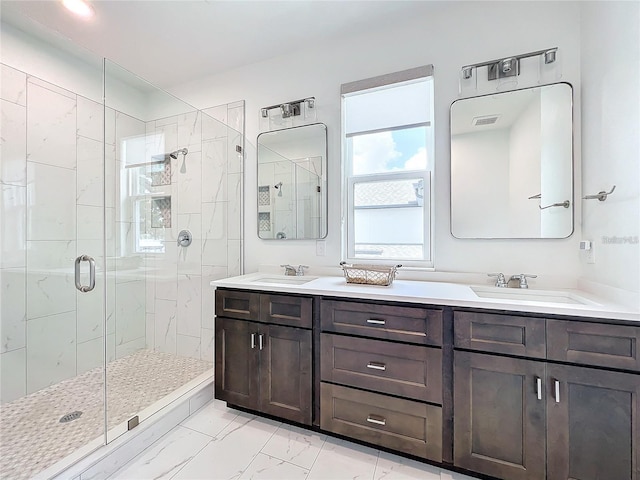 full bathroom featuring a stall shower, marble finish floor, and a sink