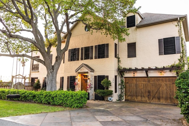 view of front of home with stucco siding, an attached garage, and driveway