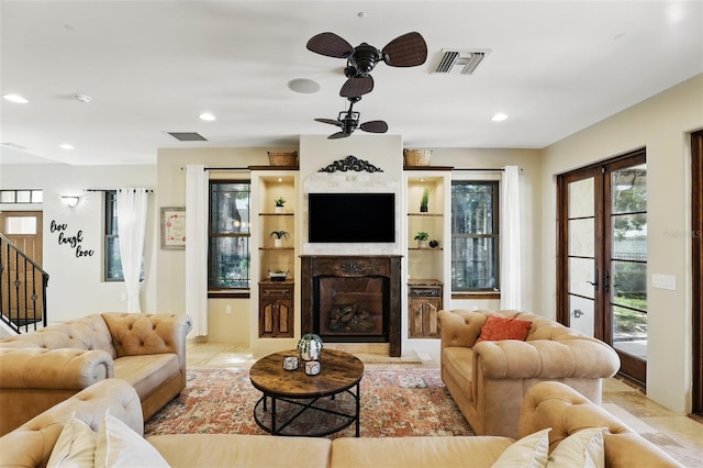 living area featuring visible vents, a fireplace with raised hearth, ceiling fan, stairway, and recessed lighting