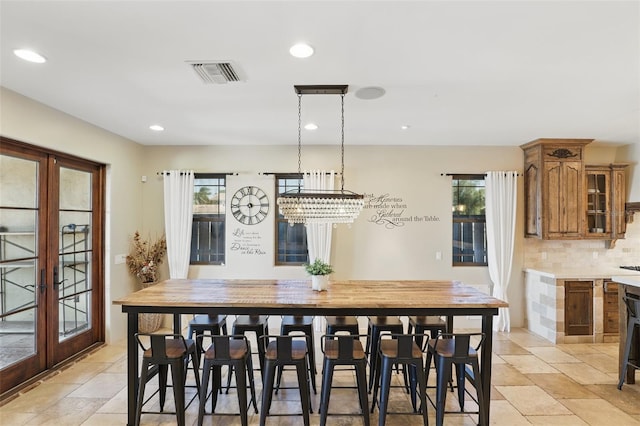 dining area with french doors, visible vents, and a wealth of natural light