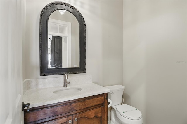 half bath featuring toilet and vanity