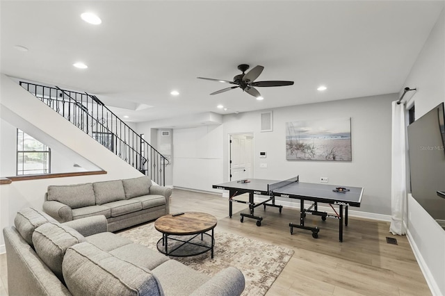 living area with stairs, a barn door, recessed lighting, light wood-style floors, and a ceiling fan