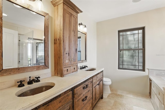 bathroom featuring double vanity, toilet, and a sink