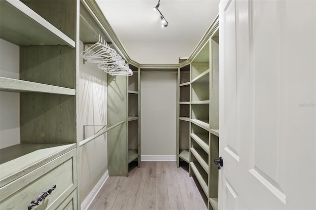 walk in closet with light wood-type flooring