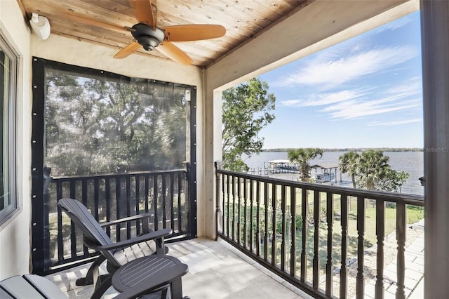 balcony featuring a water view and ceiling fan