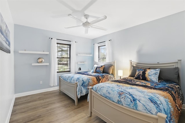 bedroom featuring a ceiling fan, wood finished floors, and baseboards