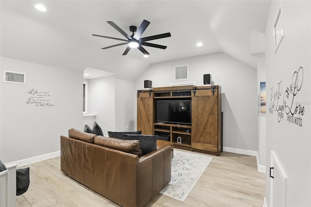 living room featuring visible vents, lofted ceiling, and light wood-style floors