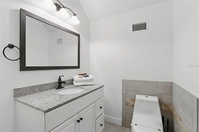 half bath featuring vanity, toilet, and visible vents