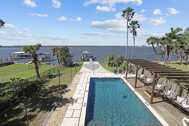 community pool featuring a yard, a water view, a patio, and fence