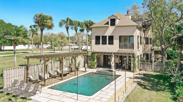 view of swimming pool featuring a pool with connected hot tub, fence, a lawn, a patio area, and a pergola