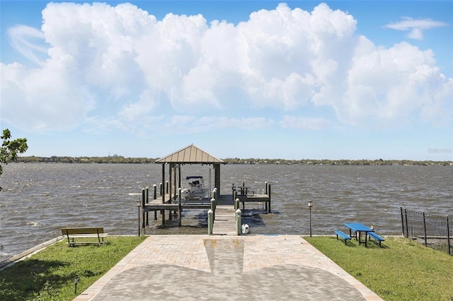 dock area with a yard, a water view, and boat lift