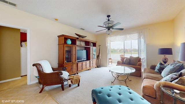 living area with light tile patterned flooring, visible vents, and a textured ceiling