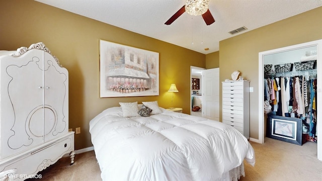 carpeted bedroom with baseboards, visible vents, ceiling fan, a closet, and a walk in closet