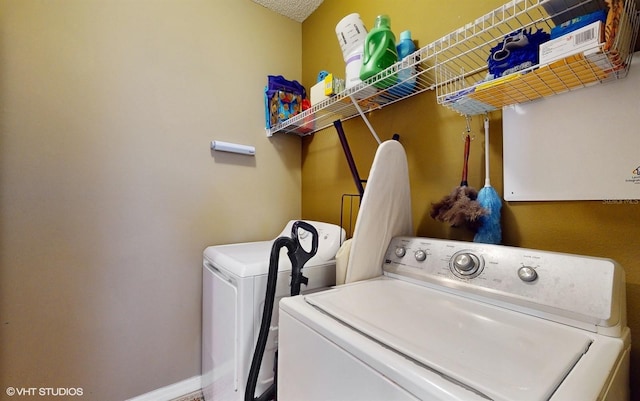 washroom with baseboards, laundry area, and washing machine and clothes dryer