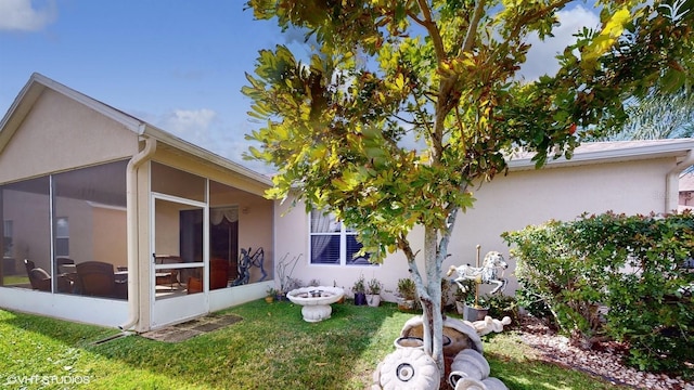 view of side of home featuring stucco siding and a lawn