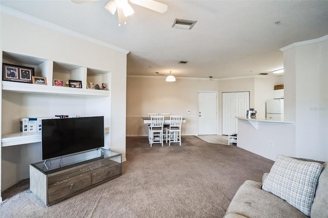 carpeted living room with ceiling fan, visible vents, and ornamental molding